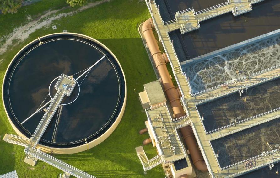 Aerial view of modern water cleaning facility at urban wastewater treatment plant. Purification process of removing undesirable chemicals, suspended solids and gases from contaminated liquid stock photo