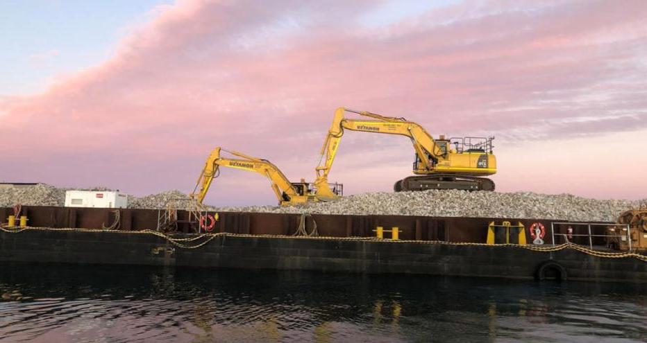 Two excavators at work on Windara Reef construction with pink sky at sunset behind them